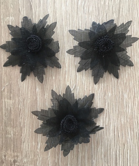 Czarne kwiaty ozdobne wykonane z organzy.