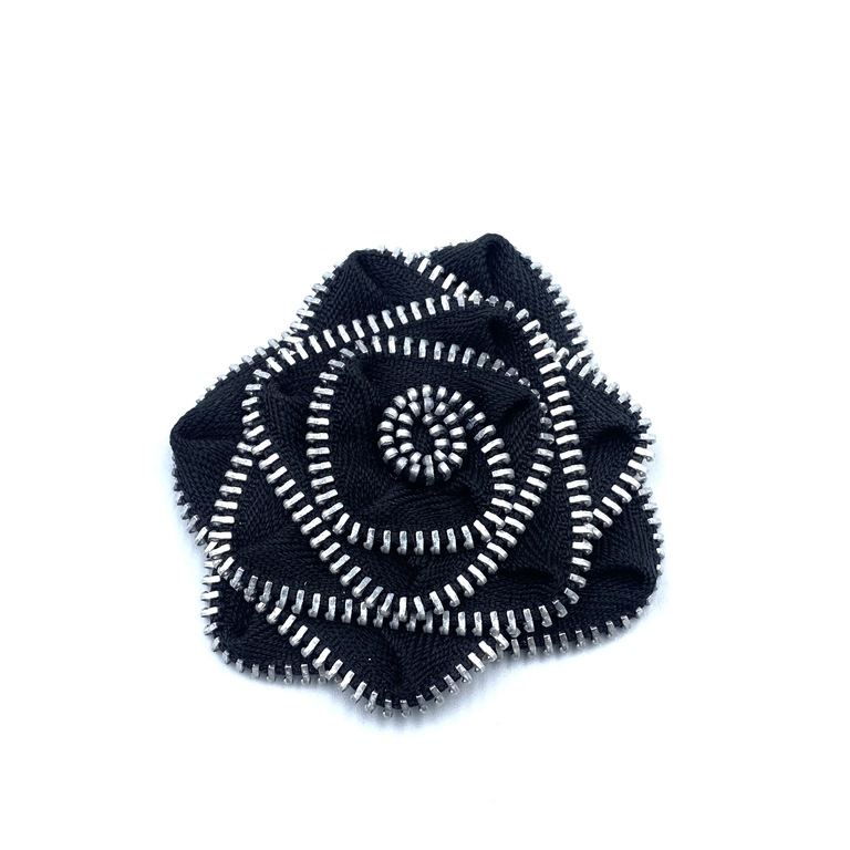Ozdobna broszka do naszycia we wzór czarnego kwiata ze srebrnym dodatkiem.